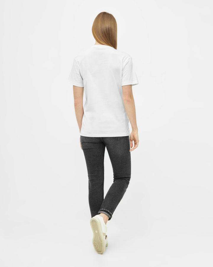 NIKIN TreeShirt weiss, T-Shirt aus Baumwolle, kombiniert mit schwarzen Jeans und weissen Sneakers.