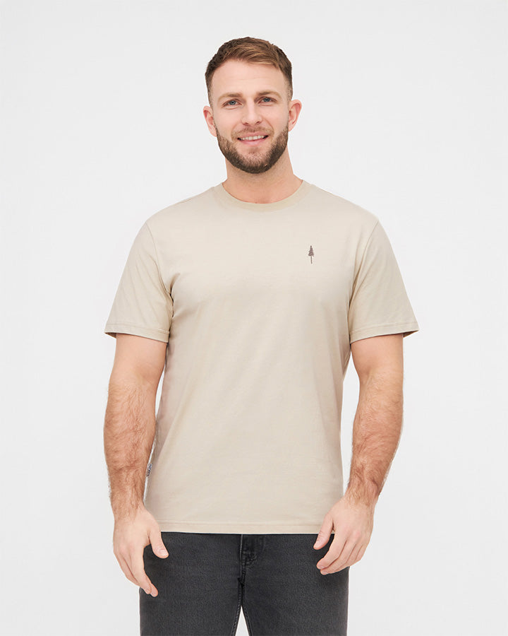 NIKIN TreeShirt Herren T-Shirt beige, Bio-Baumwolle, modelliert mit schwarzen Jeans vor weissem Hintergrund.