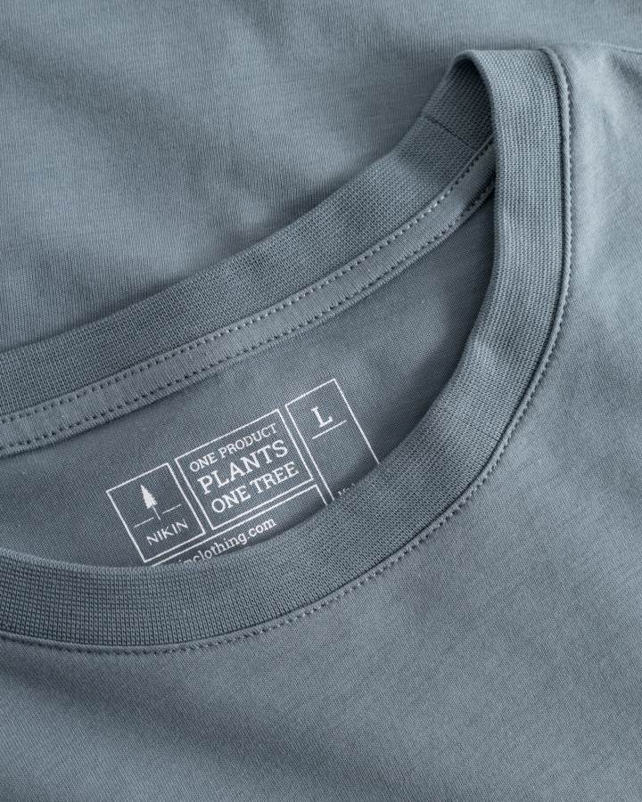 NIKIN TreeShirt Stahlblaues Bio-Baumwollshirt, GOTS-zertifiziert, fair produziert, Kragen-Detail mit Etikett.