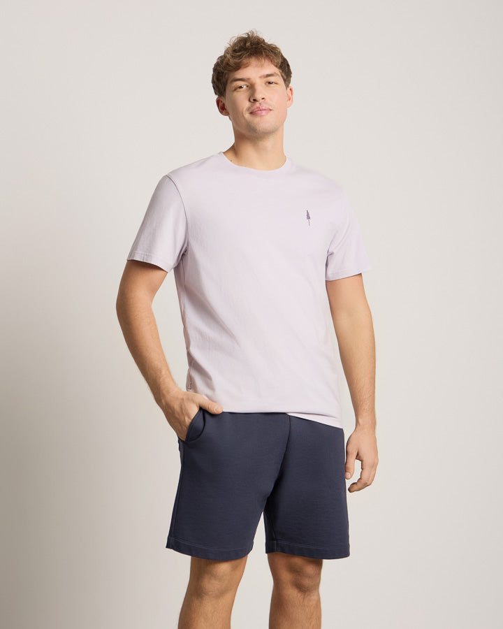 NIKIN TreeShirt Herren T-Shirt helllila, kurzarm, kombiniert mit dunkelblauer Shorts vor neutralem Hintergrund.