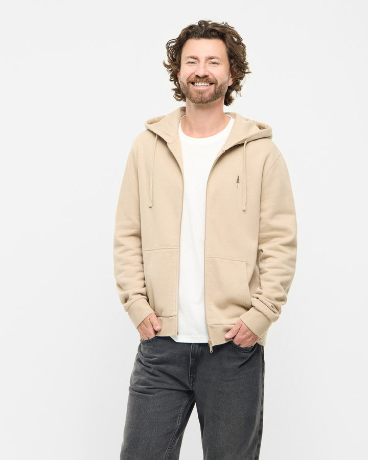 NIKIN Lot de 3 vestes TreeHoodie pour homme, couleur beige, en coton bio, associées à un t-shirt blanc et un jean foncé.