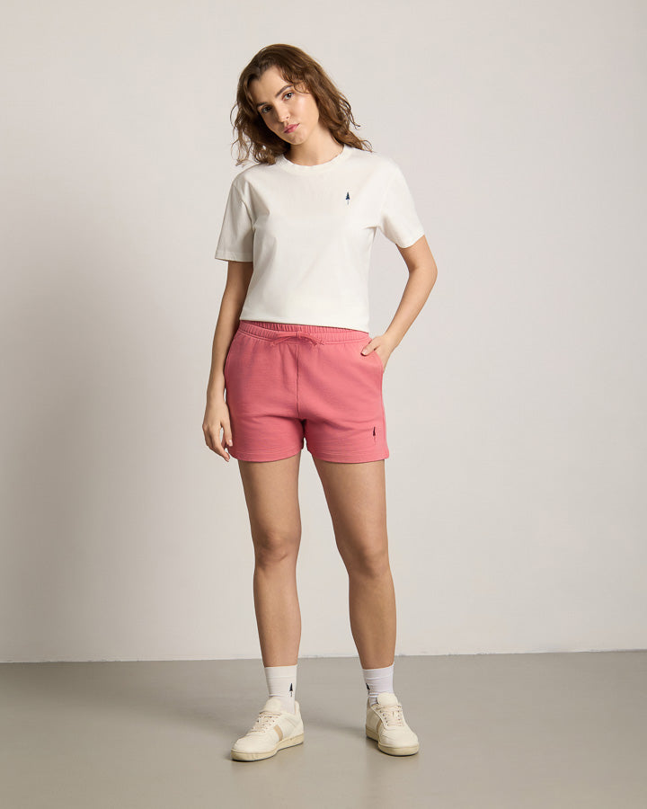 NIKIN  TreeShorts Jogging Women Wild Berry Damen-Shorts, Farbe Beere, kombiniert mit weißem T-Shirt vor hellem Hintergrund.