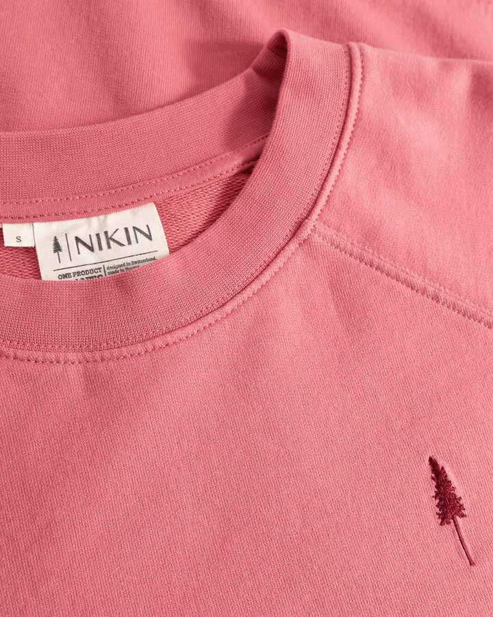 NIKIN  TreeSweater Raglan Women Wild Berry, Damenpullover, rosa, kleines Baum-Logo und NIKIN-Tag am Ausschnitt.