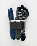 The Essential Kit TreeSocks Bundle features five pairs of socks in blue, white, green, and black—some with Nordic patterns. The set is wrapped in a black and white paper band with a forest silhouette.