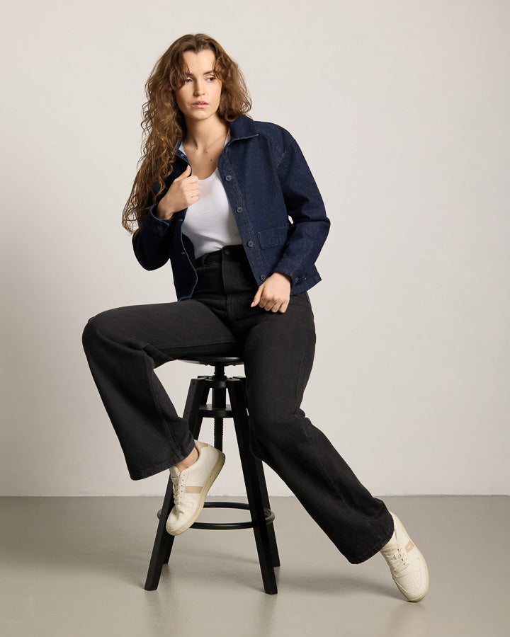 NIKIN TreeJacket Denim ReCotton Women, Damenjacke, dunkelblau, nachhaltiges Material, kombiniert mit einer schwarzen Hose.