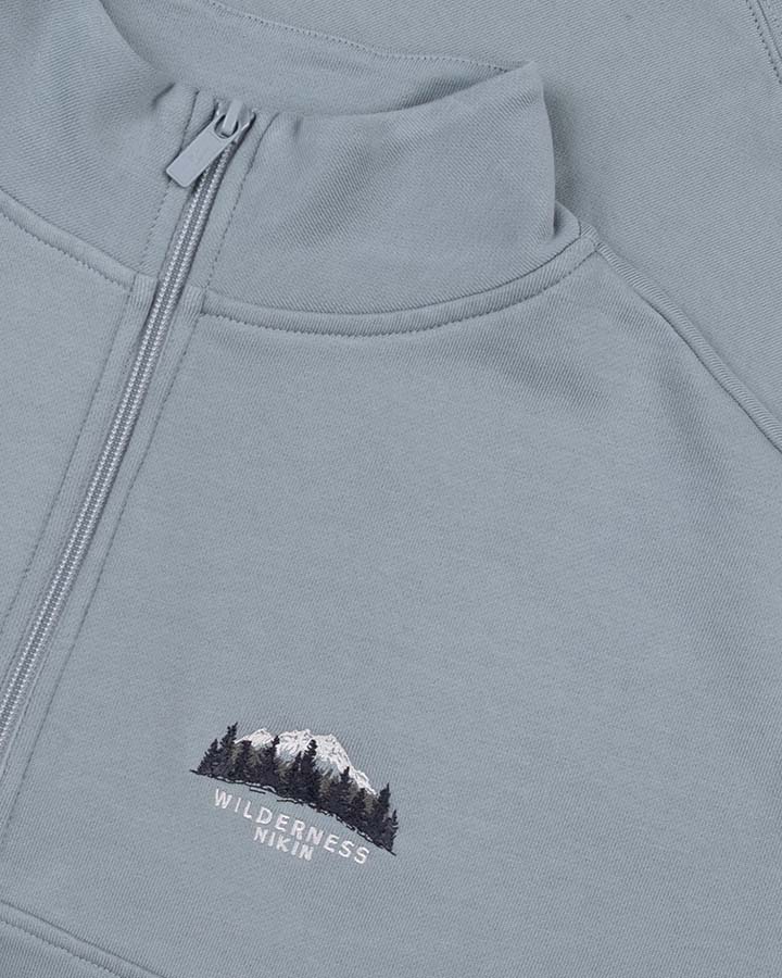 NIKIN  NIKIN TreeSweater Quarter Zip Muntogna, blau, mit gestickten Bergen und Bäumen, Bio-Baumwolle.