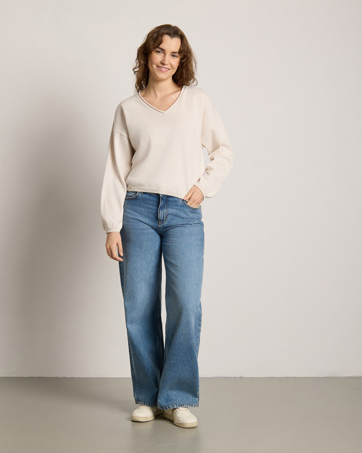 NIKIN TreePullover Damen Strickpullover, Farbe Faded Pearl, kombiniert mit blauen Jeans und weissen Schuhen.