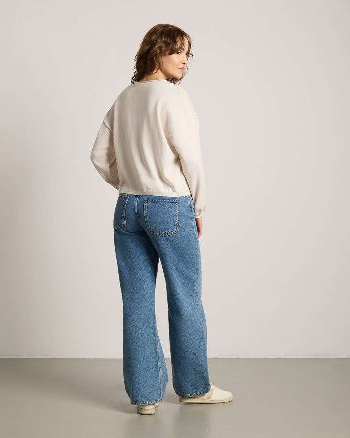 NIKIN TreePullover Knitted Light Damen, Faded Pearl, Pullover aus Strick, kombiniert mit blauen Jeans und weissen Schuhen.