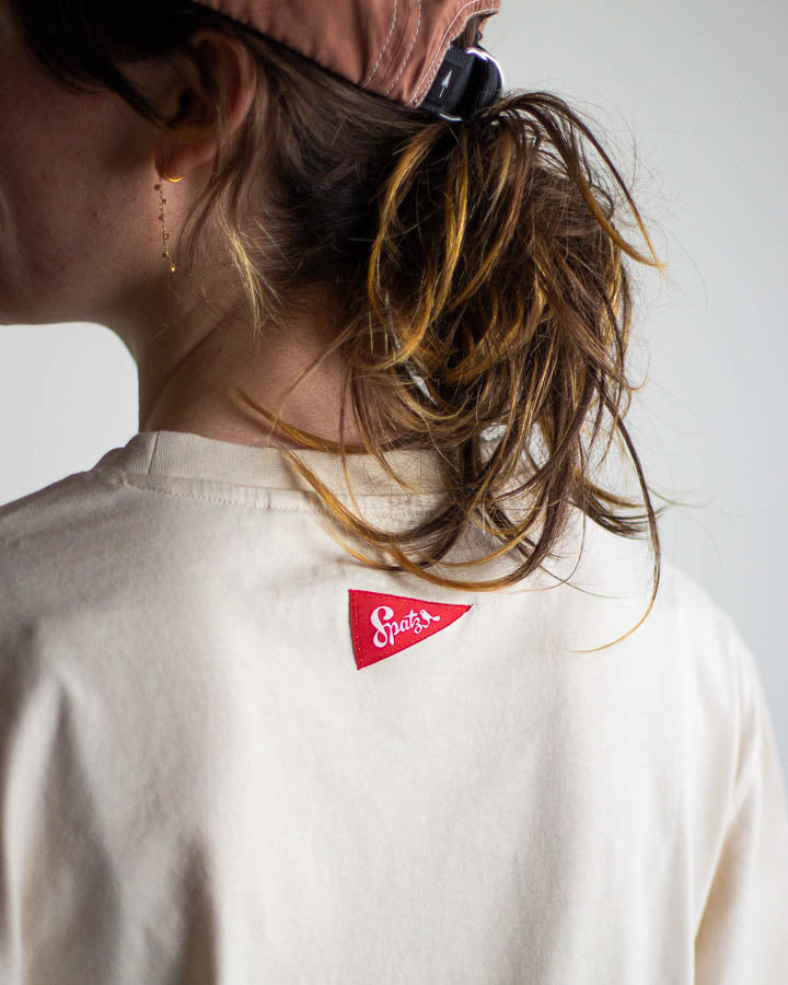 NIKIN Chalk TreeShirt Pocket Spatz T-Shirt mit rotem Nackenlabel, unordentlicher Pferdeschwanz, passende Kappe.