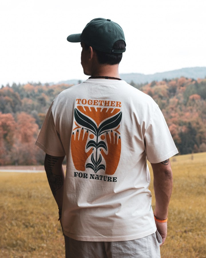 NIKIN T-shirt TreeShirt TreePlanter, imprimé « Relaxed Chalk », coupe ample, couleur blanche, porté sur le terrain avec des arbres en arrière-plan.