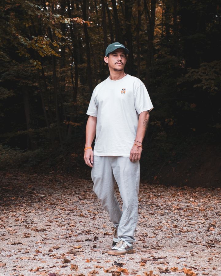 NIKIN T-shirt pour homme TreeShirt TreePlanter, imprimé « Relaxed Chalk », blanc, photographié sur un sentier bordé de feuillage en automne.