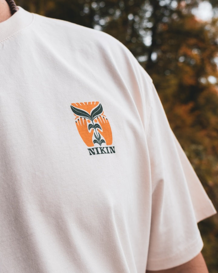 NIKIN TreeShirt TreePlanter Print Relaxed Chalk T-Shirt, orange-grüner Blatt-Print, NIKIN-Logo auf der Brust.